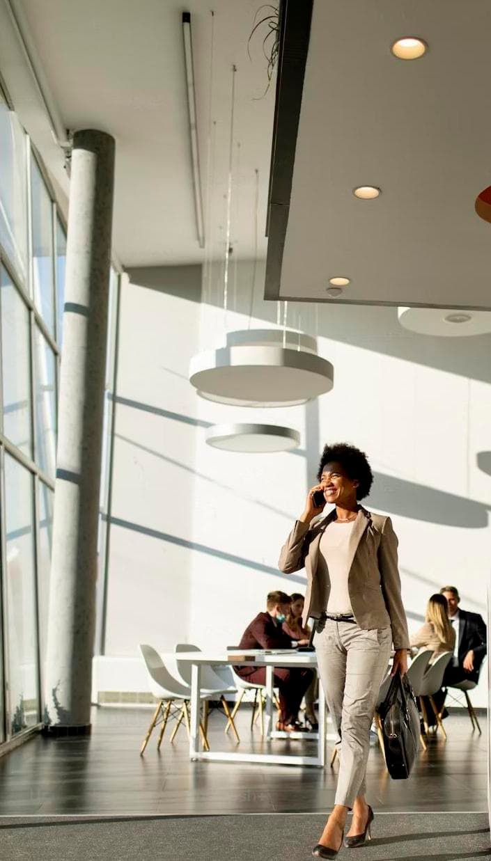 teammate with bag using mobile phone and walking in the office